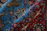 Detailed view of the pictorial tiger and bird motifs on a hand-knotted vintage Qom carpet.