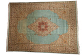 Vintage Tabriz carpet featuring a central medallion on an open, power blue field with floral borders.