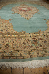 Low angle on the plush pile of a vintage Tabriz carpet, showing its floral border and ivory fringe.