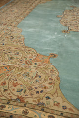 Angled view across the plush, abrashed blue field and detailed ivory spandrel of a Tabriz carpet.