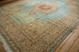 Vintage Tabriz carpet's ornate ivory spandrel and soft blue field shown from an angled view.