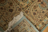 A vintage Tabriz carpet's folded corner reveals the pale seafoam foundation, ivory fringe, and full pile.
