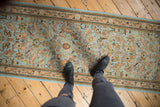 A personal perspective over a vintage Tabriz rug runner, showing its powder blue field and dense floral pattern.