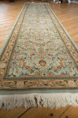 A vintage Tabriz runner viewed down its length, showing delicate allover vinery on a powder blue field.