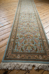 Angled view down the length of a vintage Tabriz runner with soft powder blue and rose florals.