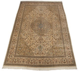 Perspective view of a vintage Persian Tabriz carpet showing its detailed central medallion and ivory field.