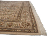Angled view of a vintage Tabriz carpet highlighting its floral border, full pile, and clean ivory fringe.