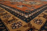 Detail of hand-knotted vintage Meshkin rug showing full pile, geometric animals, and rust, navy, sand colors.