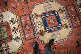Detail of vintage Meshkin rug: geometric medallion, hook and latch motifs, and animal figures.