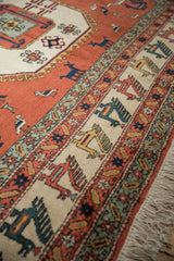Vintage Meshkin rug border with terracotta, ivory, blue layered bird motifs, and matching fringe.