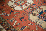 Vintage Persian Meshkin carpet detail showcasing terracotta field, geometric birds, and hook motifs.