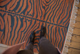 Kilim rug showcasing tiger stripe pattern with rust, burnt orange, and charcoal abrashes.