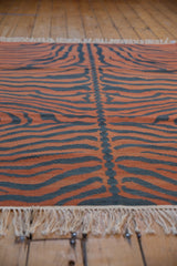 Hand woven tiger pattern with central spine in rust, charcoal, and fringes.