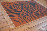 Close-up of vintage hand-woven Indian Tiger Kilim rug with natural fringe and rust charcoal abrashes.