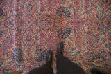 Overhead view showing the scale of the detailed millefleur pattern in ruby and sapphire tones.