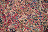 Detailed close-up of the vintage Lavar Kerman's dense millefleur pattern in ruby and sapphire.