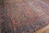 Flowing Rococo contours and a detailed millefleur design on a vintage Lavar Kerman Persian carpet.
