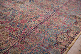 A vintage Kerman carpet's ivory millefleur field next to its seafoam blue Rococo-style border.