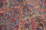 European-influenced Rococo details within the dense millefleur pattern of a vintage Lavar Kerman.