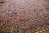 Angled view of the detailed millefleur field and Rococo-style borders on a vintage Lavar Kerman carpet.