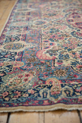 Blush, navy, and ivory blossomed floral design on a vintage Lavar Kerman rug with intact side cord.