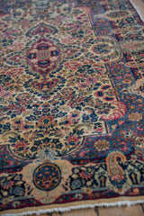 Intricate milfleur floral design on ivory field and navy border of the Lavar Kerman rug.