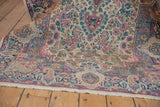 Vintage Lavar Kerman rug corner with ivory milfleur, blush, blue, gold border, and fringe.