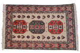 Vintage Meshkin rug with geometric medallions and bird motifs in ivory, rust, and mallard green.