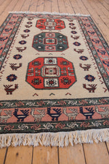 Vintage Persian Meshkin rug detail with geometric red medallion, finned peacocks, and bird border.