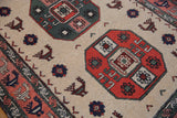 Rust, green geometric gul medallions with ivory field and finned peacock motifs.