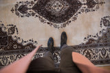 A view for scale, highlighting the plush, full pile of a vintage Tabriz carpet.
