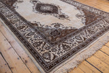 Angled perspective of a vintage Tabriz carpet highlighting its plush wool pile and ornate brown border.