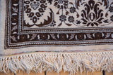 Detail of rainbow-colored yarns and knotted ivory fringe on a vintage Persian Tabriz rug.