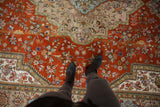 Vintage Tabatabaie Tabriz carpet's ornate burnt orange floral field with interconnected blossoms.