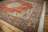 Vintage Tabriz carpet corner with ivory fringe and ornate beige, rust, and blue floral border.