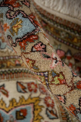 Ornate floral and vine motifs on the plush, hand-knotted pile of a vintage Tabriz rug.