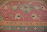 Stone wash Dhurrie rug border with geometric motifs in pale seafoam and raspberry.