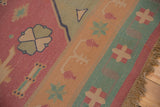 Fringe and geometric motifs in pale raspberry, seafoam, and sand on this vintage Dhurrie rug.