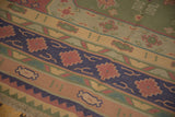 Close-up of vintage Dhurrie rug with primitively drawn geometric bands and fringe.