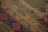 Close-up: Geometric patterns and flatweave texture of vintage Dhurrie in olive, pale red, and navy.