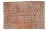 Vintage Japanese Art Deco carpet with a plush, dusty rose open field and ornate corner floral sprays.
