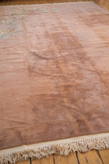 The soft, blankety texture and full pile of a vintage Art Deco carpet's dusty rose field.