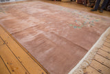 Light reflecting across the plush, dusty rose open field of a vintage Japanese Art Deco rug.