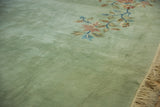 Plush pale seafoam green pile, ornate floral vines, and ivory fringe on a Japanese carpet.