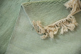 Vintage Japanese carpet's plush seafoam green pile, secured reverse, and ivory fringe.