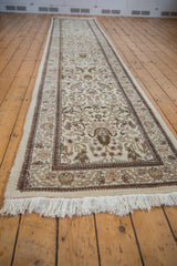 Vintage Tabriz runner at an angle, displaying its full length and intricate floral pattern on an ivory field.