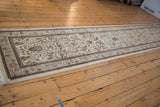 A long, angled view of the vintage Tabriz runner, showcasing its full length and floral design.