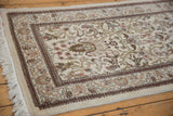 Corner detail of a Persian Tabriz runner showing its floral border and plush, hand-knotted pile.