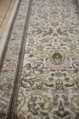 Angled view of a vintage Tabriz runner's intricate forest scene and plush, full pile.