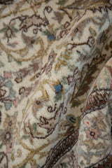 A folded view showing the full, plush pile of a vintage Tabriz rug with intricate flora.